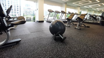 A gym with treadmills, exercise balls, and weight machines.