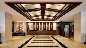 Eine geräumige Lobby mit hoher Decke, einem Empfangstresen und modernem Design.