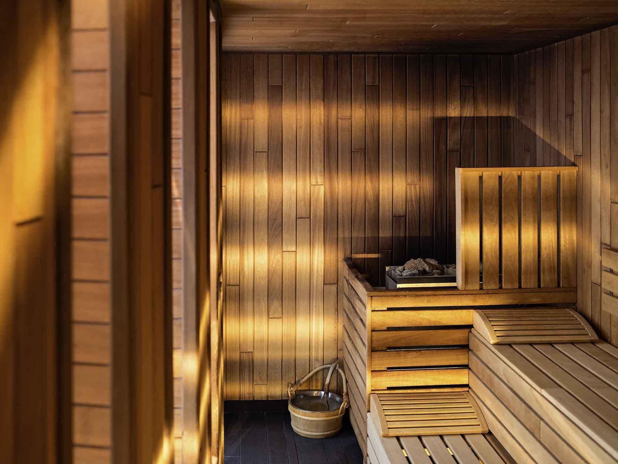 A sauna with wooden benches and a bench seat, a wooden bench with a seat, and a wooden bench with a backrest.