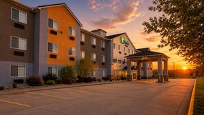A multi-story hotel with a covered entrance and a parking lot.