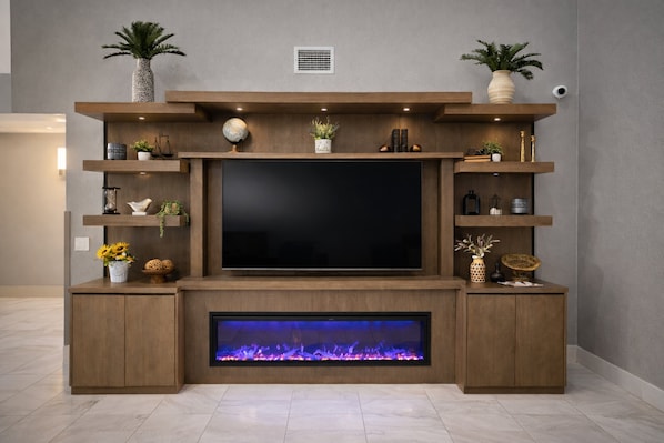 A modern entertainment unit with a flat-screen TV, built-in shelves, and a fireplace. - Holiday Inn Express & Suites Fort Pierre by IHG (Fort Pierre)