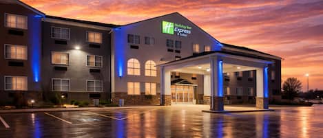A Holiday Inn Express building with a covered entrance, large windows, and a parking lot.