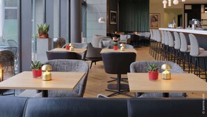 Un restaurante moderno con techos altos, ventanas amplias y una zona de bar con taburetes. Las mesas están dispuestas para comer, y hay plantas en macetas sobre ellas.