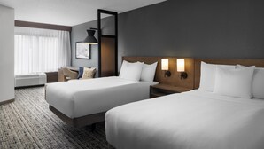 A hotel room with two beds, a desk, a chair, a lamp, and a large window with curtains. - Hyatt Place Charlotte Airport/Lake Pointe (Charlotte)