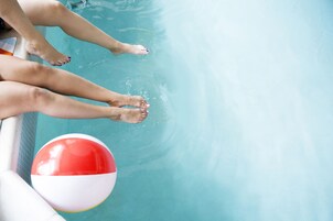 Una piscina al aire libre, sombrillas, sillones reclinables de piscina