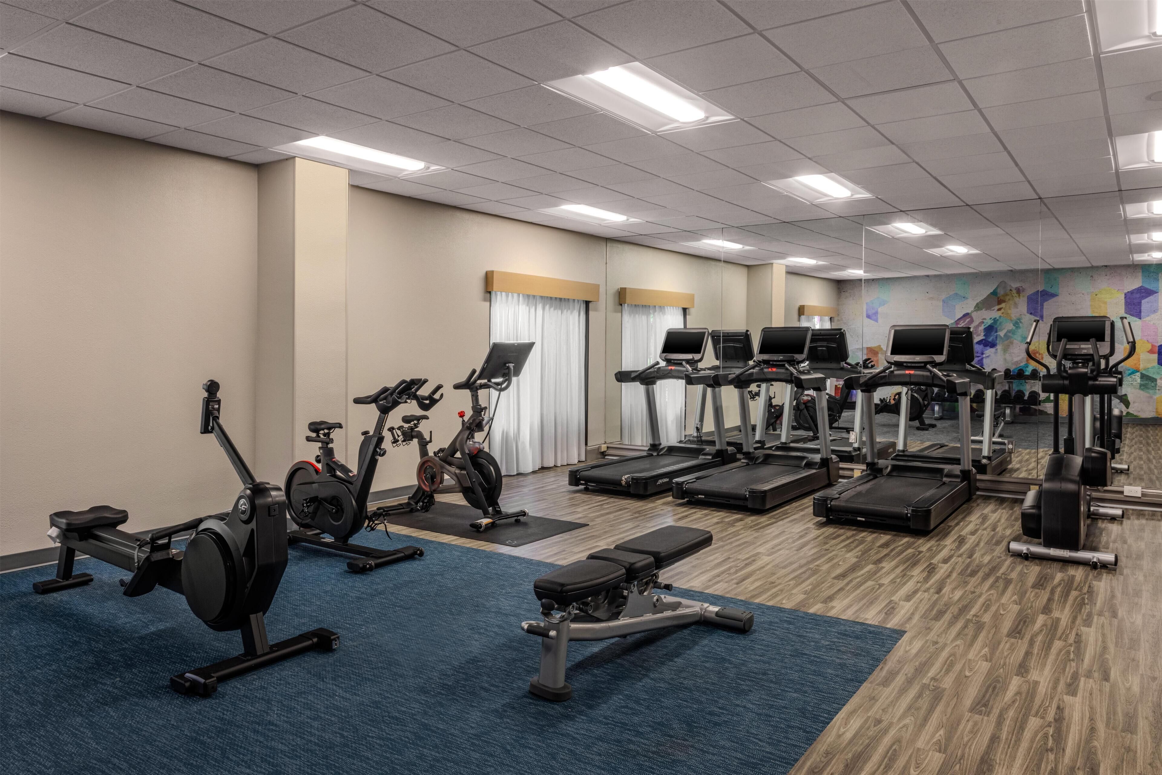 A gym with stationary bikes, treadmills, and weight machines.