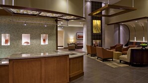 A modern lobby with a reception desk, seating area, and a fireplace. - Hyatt Place Charlotte Airport/Lake Pointe (Charlotte)