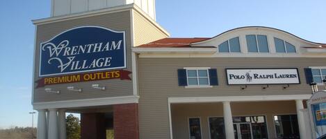 A building with a sign for Wrenham Village Premium Outlets and a Polo Ralph Lauren store.