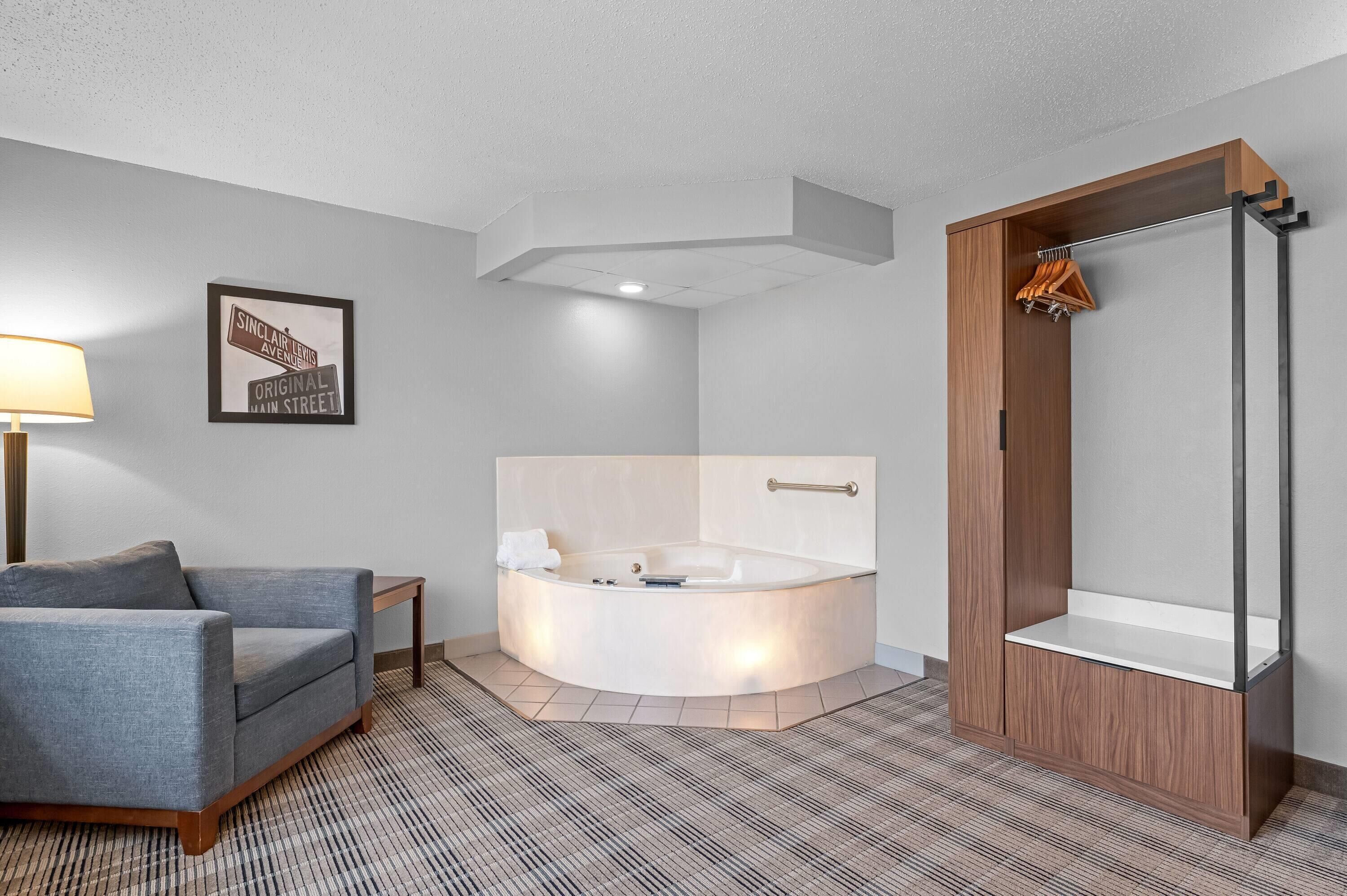 A modern bathroom with a freestanding bathtub, a wooden vanity, and a framed street sign.