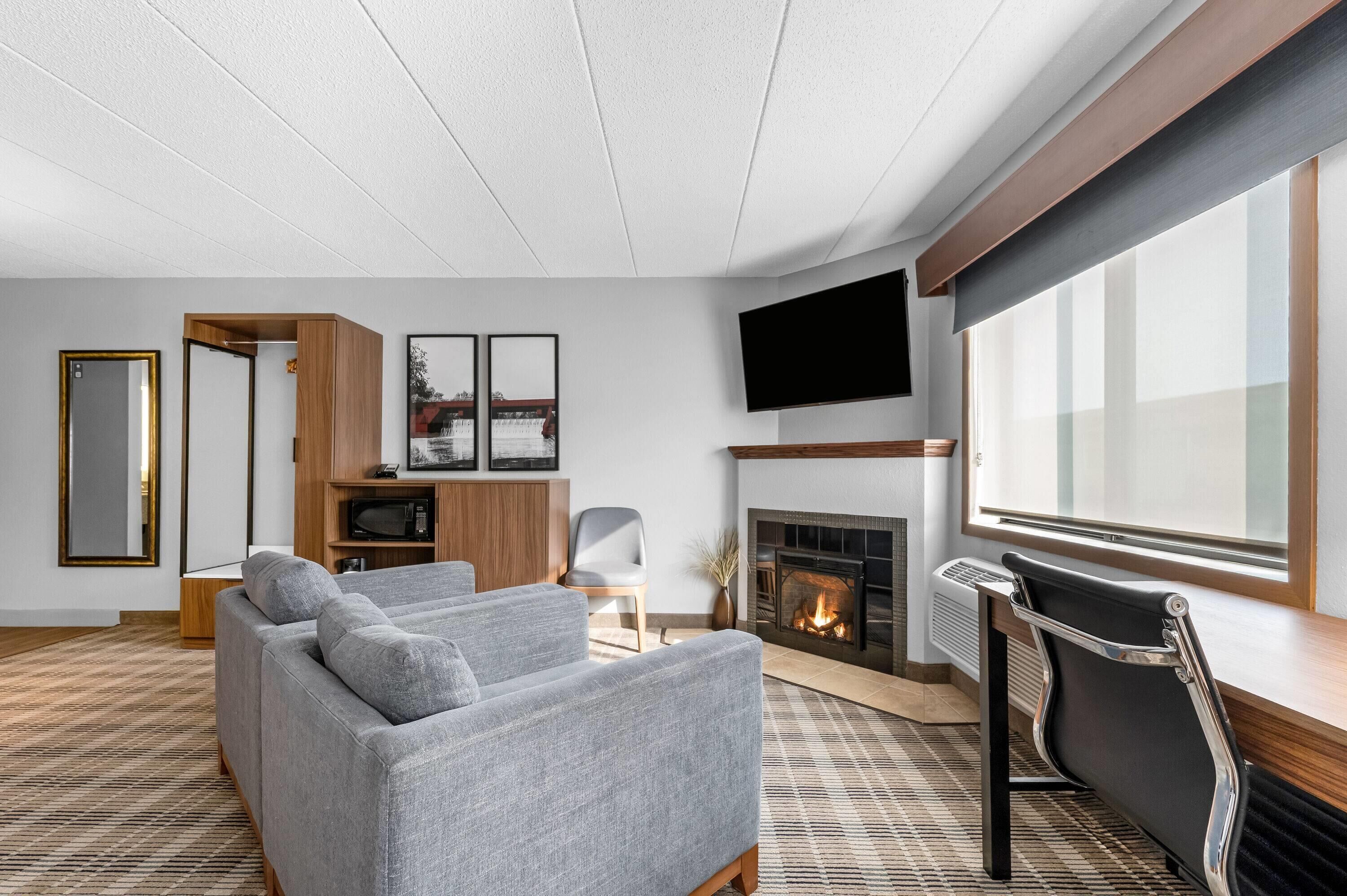 A modern living room with a fireplace, a flat-screen TV, and a sofa.