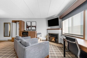 A modern living room with a fireplace, a flat-screen TV, and a sofa.