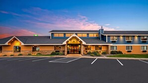 A hotel with a main entrance, a parking lot, and a clear sky. - AmericInn by Wyndham Sauk Centre (Sauk Centre)
