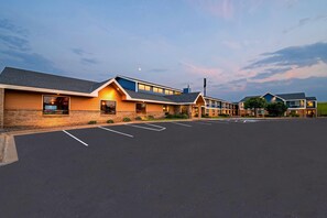 A modern hotel with a parking lot and a row of buildings.