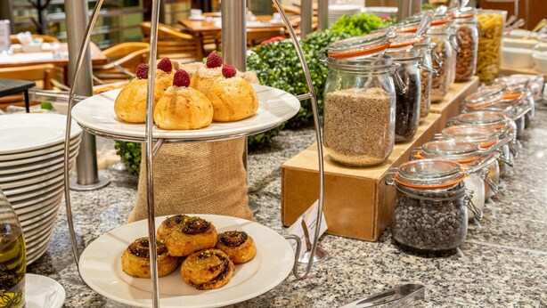 Un buffet proposant des pâtisseries et divers aliments présentés dans des bocaux.