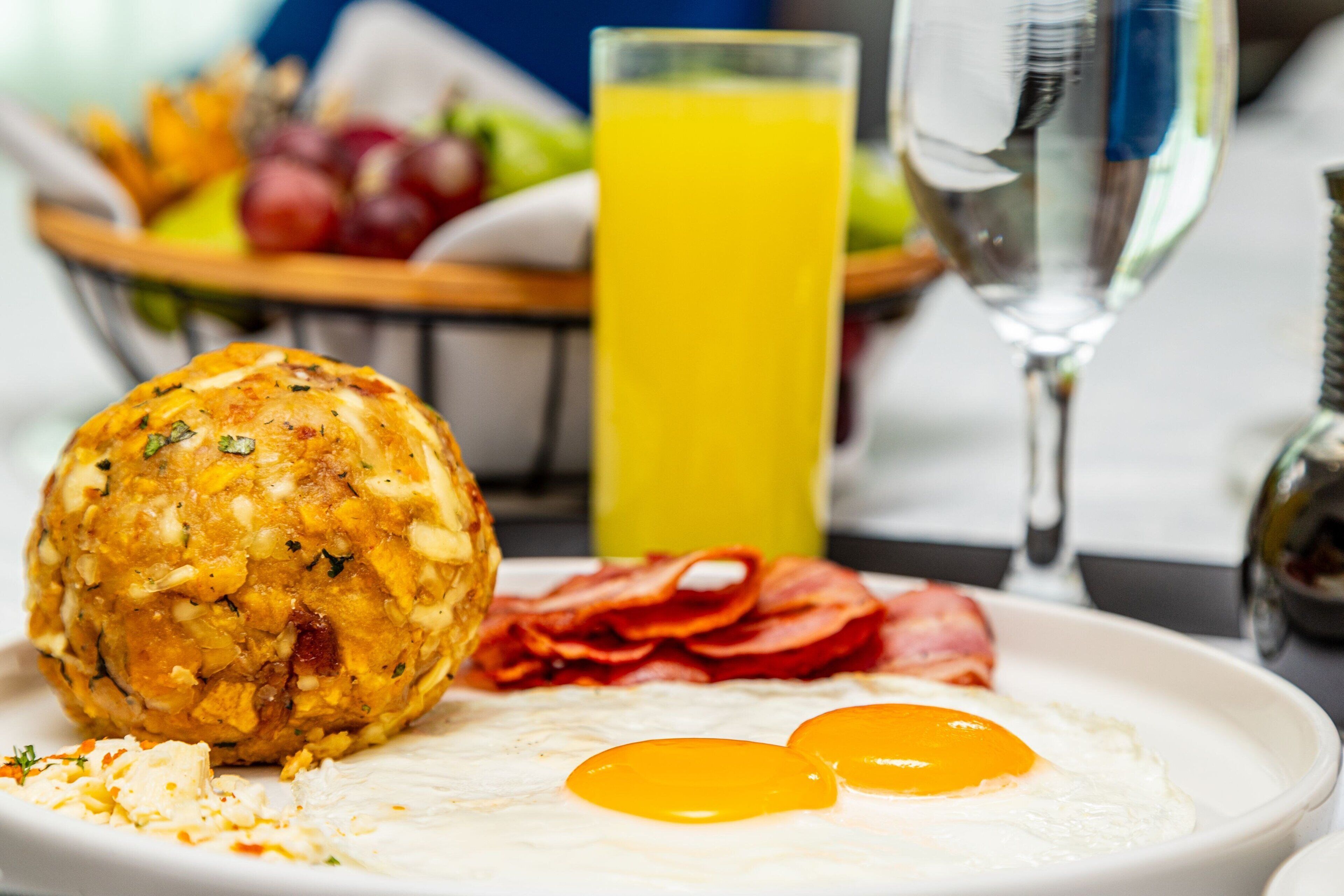 A breakfast plate with eggs, bacon, and a muffin.