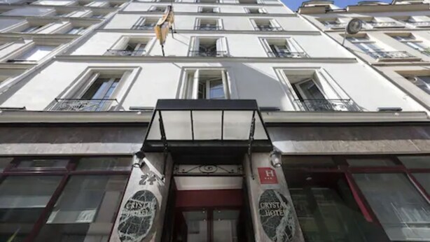 A building with multiple floors, large windows, and a sign indicating it is a hotel. - Crystal Hôtel (Paris)