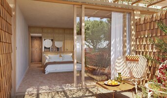 Un dormitorio con una cama, una mesita con frutas y una silla.