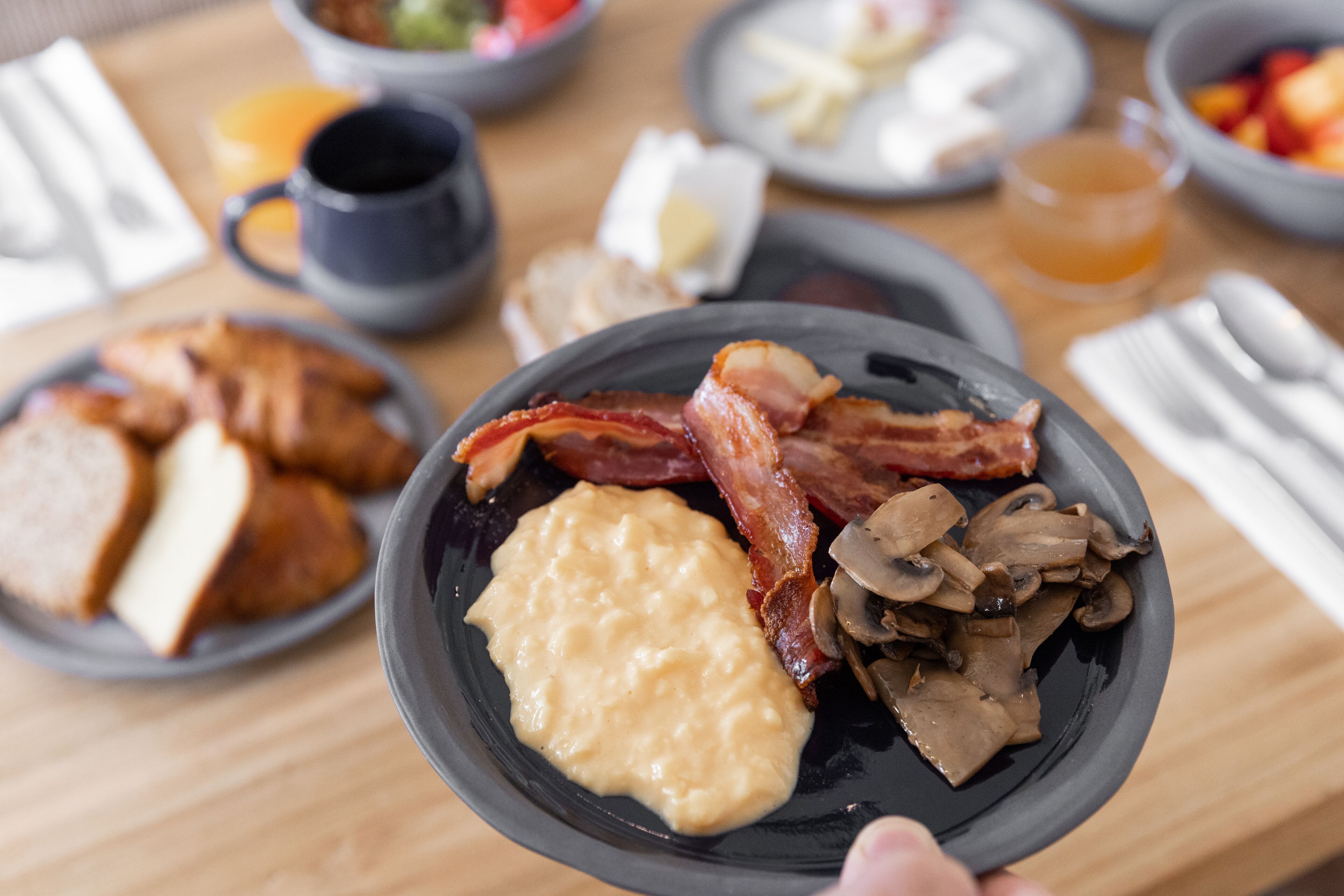 A breakfast plate with eggs, bacon, and mushrooms.
