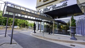 Entrada de un hotel con toldo de vidrio y un cartel que dice 'Park Hotel Grenoble'.