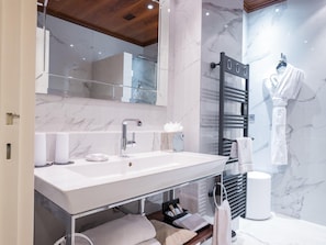 A modern bathroom with a marble vanity, a glass shower enclosure, and a towel rack. - Park Hotel Grenoble - Handwritten Collection (Grenoble)