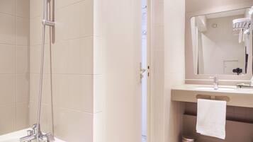 A bathroom with a shower, sink, and mirror.