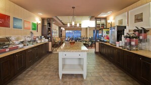 A modern kitchen with granite countertops, dark wooden cabinets, and a central island. - Russell Inn & Suites (Starkville)