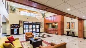 A spacious lobby with a high ceiling, a chandelier, a reception desk, and a vending machine. - Comfort Suites Westchase Houston Energy Corridor (Houston)