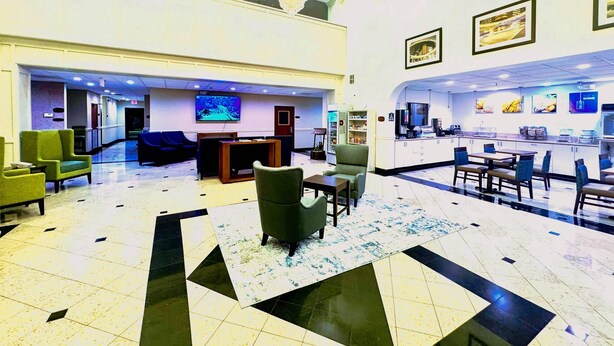 A spacious lobby with a reception desk, seating area, and a bar. - Comfort Suites Westchase Houston Energy Corridor (Houston)