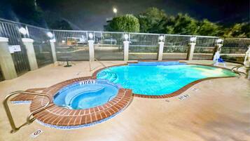 Una piscina al aire libre de temporada, sombrillas