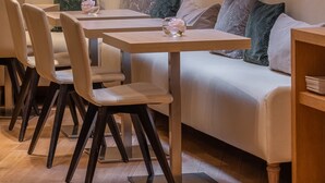 A modern dining area with a sofa, tables, and chairs. - Hôtel Le Monna Lisa by Inwood Hotels (Paris)