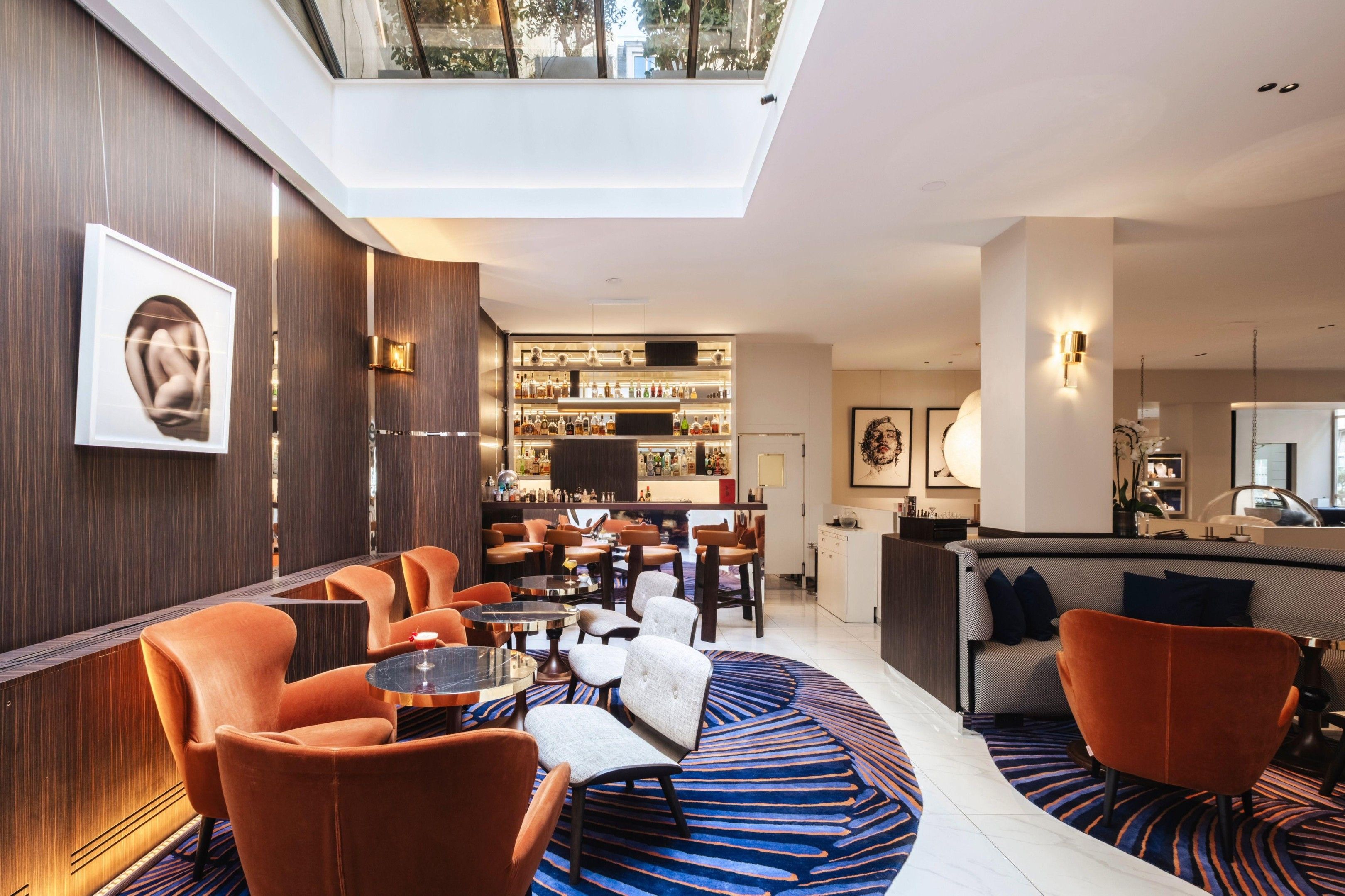 Un intérieur moderne avec un bar, des espaces pour s’asseoir et une verrière.