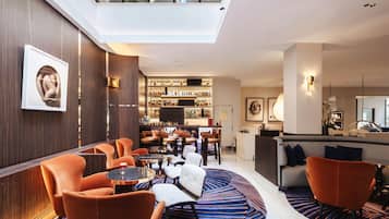Un intérieur moderne avec un bar, des espaces pour s’asseoir et une verrière.