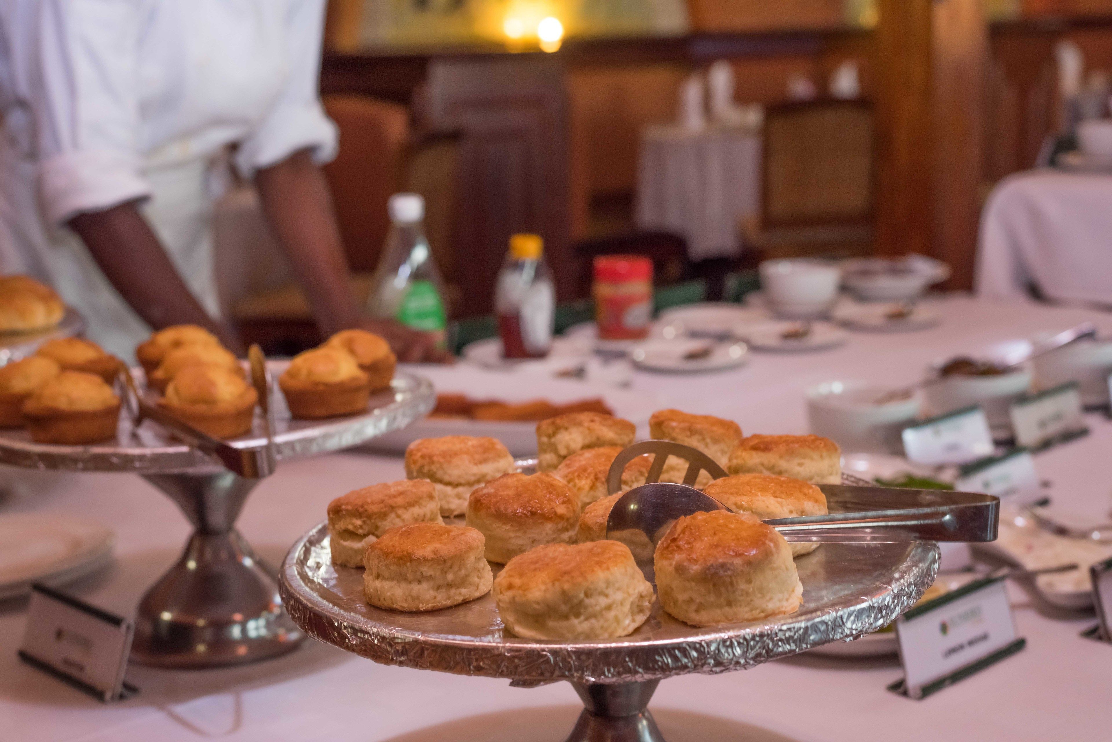 Una mesa de buffet con diversas opciones de panadería, como muffins y galletas.