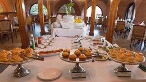 A buffet setup with various pastries and dishes.