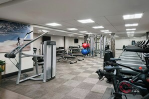A gym with treadmills, weight machines, and exercise balls.