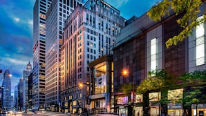 A modern urban street with high-rise buildings, including a prominent 'The Gwent' and 'Nordstrom' sign.