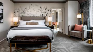 Ein modernes Hotelzimmer mit einem großen Bett, einer Bank, einem Sofa und einem kleinen Tisch.