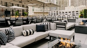 An outdoor seating area with sofas, chairs, and a fire feature.