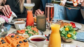 A breakfast setting with waffles, a bottle of orange juice, and various dishes.