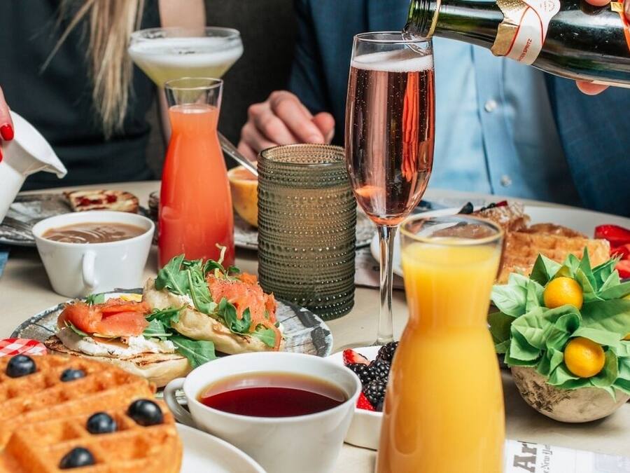 A breakfast setting with waffles, a bottle of orange juice, and various dishes.