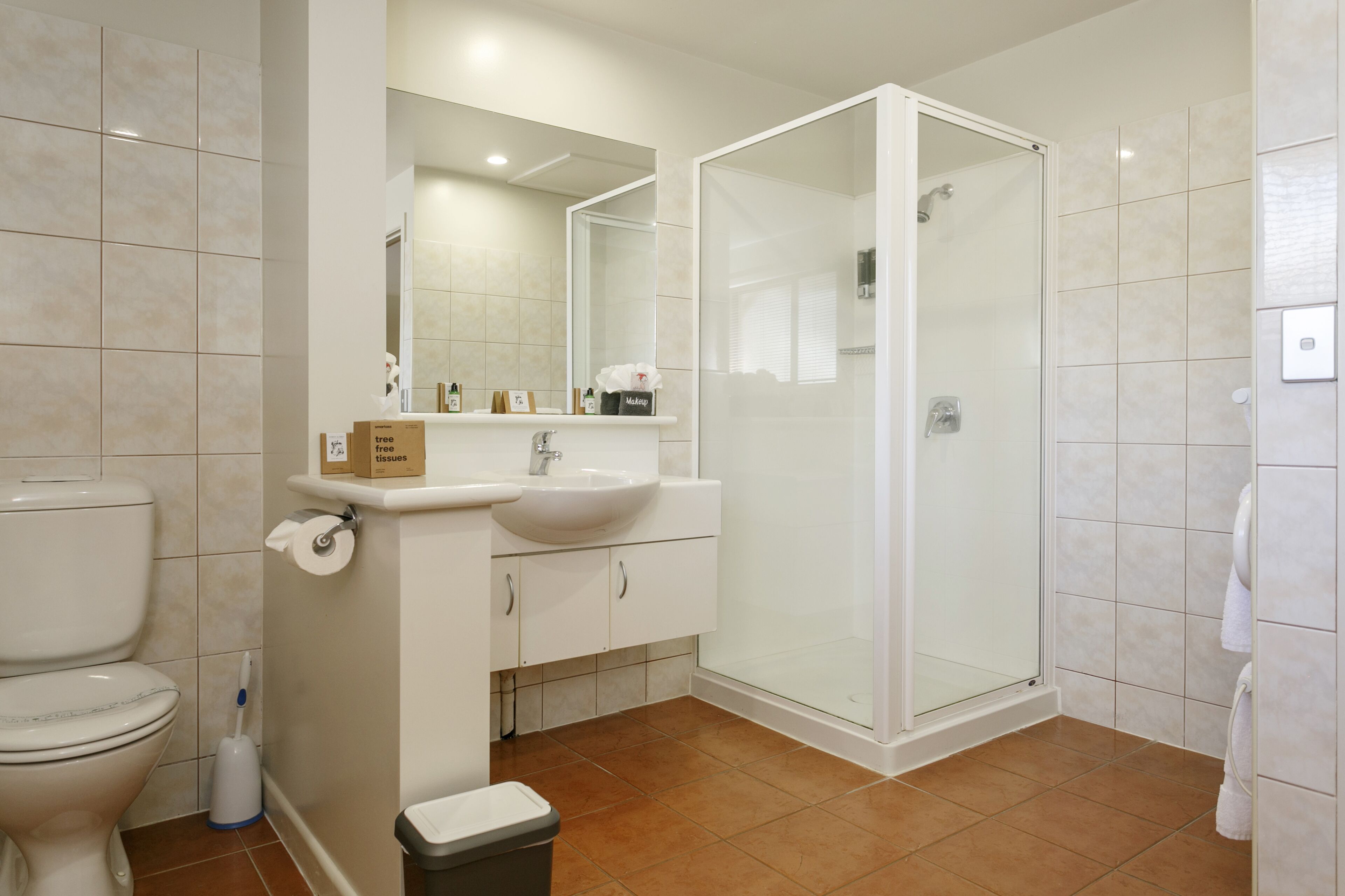 A modern bathroom with a toilet, sink, and shower.