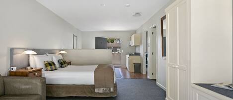 A hotel room with a bed, a sofa, a desk, and a wardrobe.