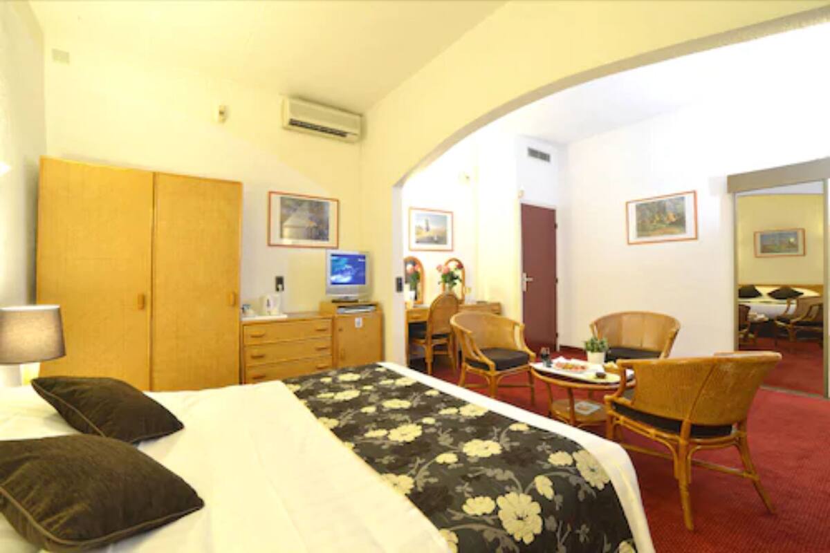 Une chambre d’hôtel avec un lit, un bureau, une chaise et une petite table sur laquelle se trouve une assiette de nourriture.