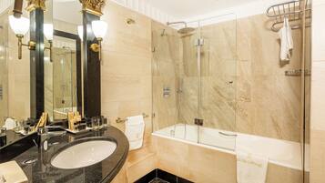 Un baño moderno con ducha envuelta en vidrio, bañera y tocador con lavamanos.