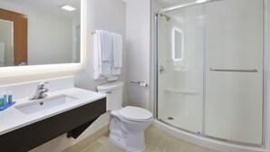 A modern bathroom with a white sink, toilet, and glass-enclosed shower. - Holiday Inn Express Tiffin by IHG (Tiffin)