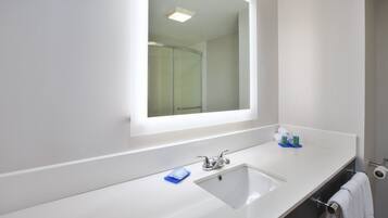 A bathroom with a white sink, a mirror, and a towel rack.
