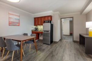Una cocina moderna con refrigerador, microondas y armarios de madera.