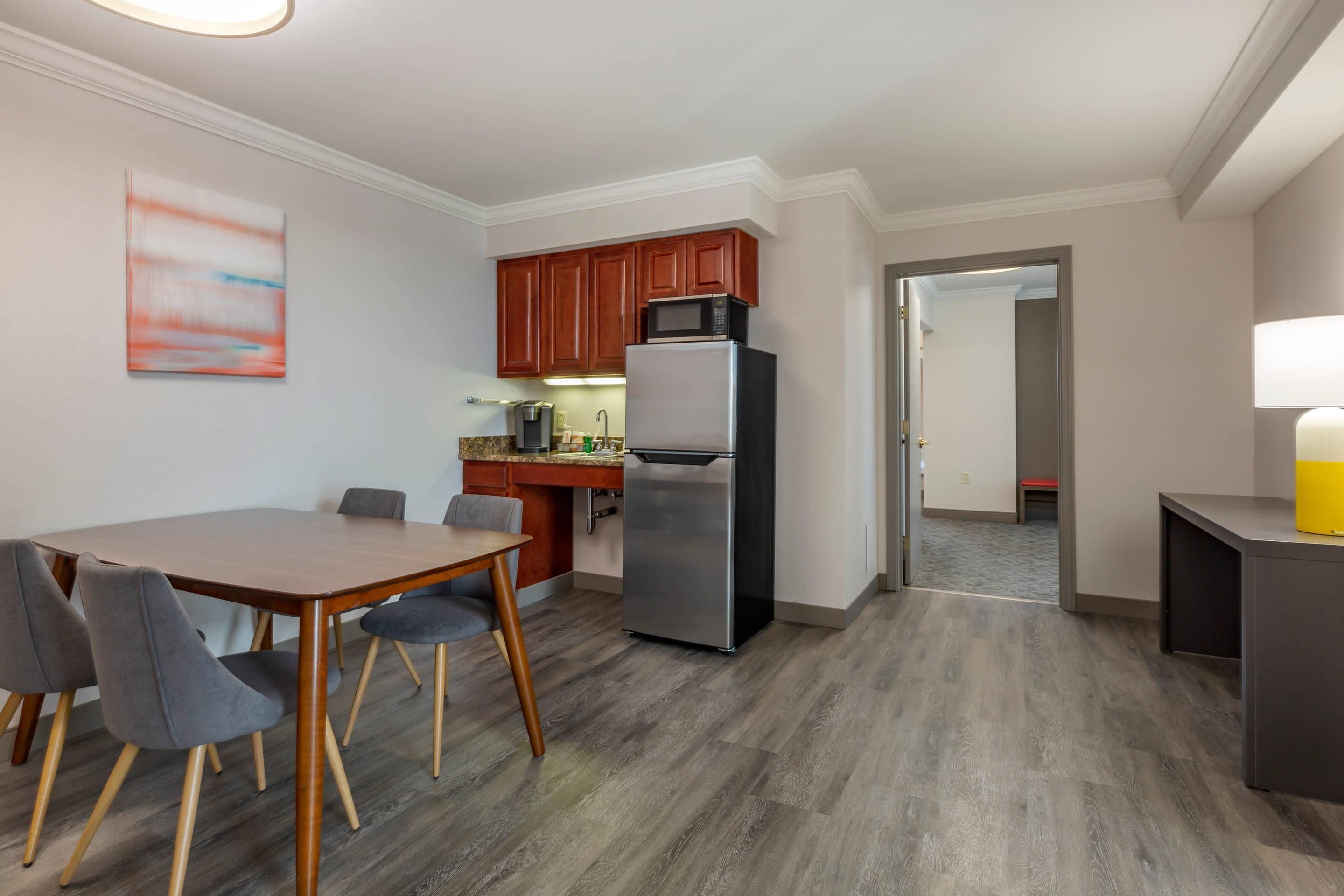 A modern kitchen with wooden cabinets, a stainless steel refrigerator, and a microwave.