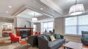 A spacious living area with a fireplace, sofas, and a coffee table. - Comfort Inn & Suites Hadley - Amherst (Hadley)