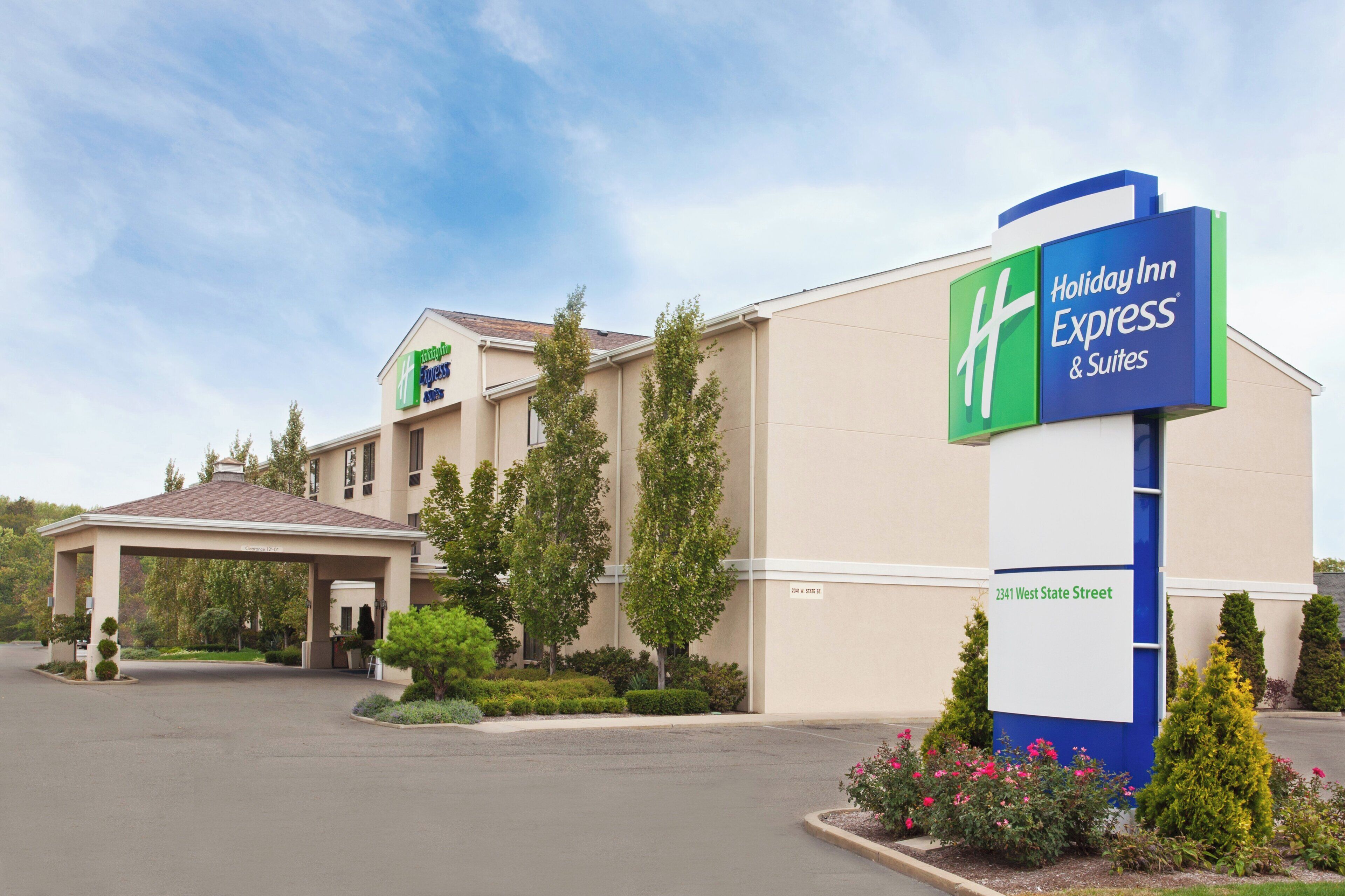 Edificio de Holiday Inn Express & Suites con entrada techada y estacionamiento.